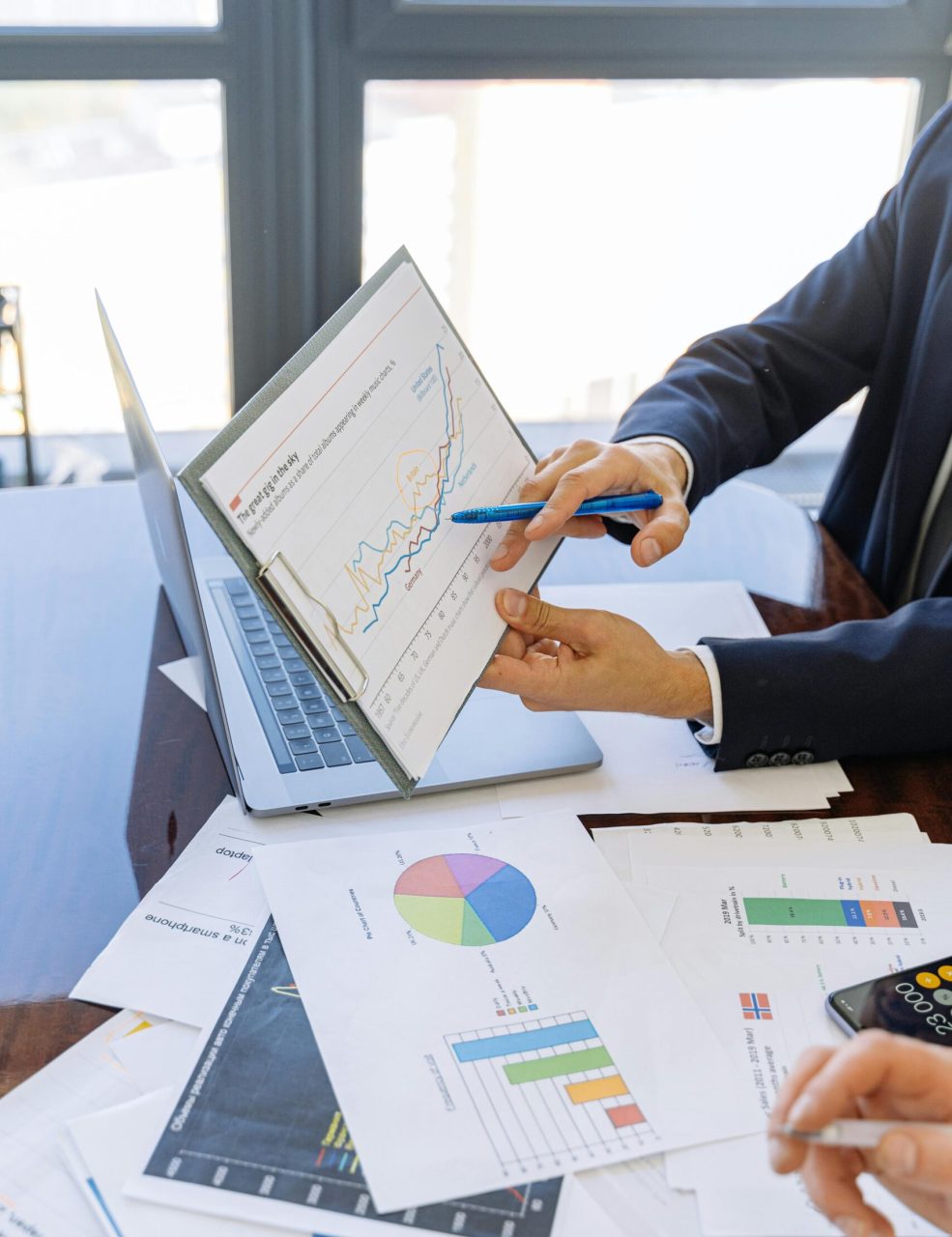 Business professionals discussing financial graphs and charts in an office setting.